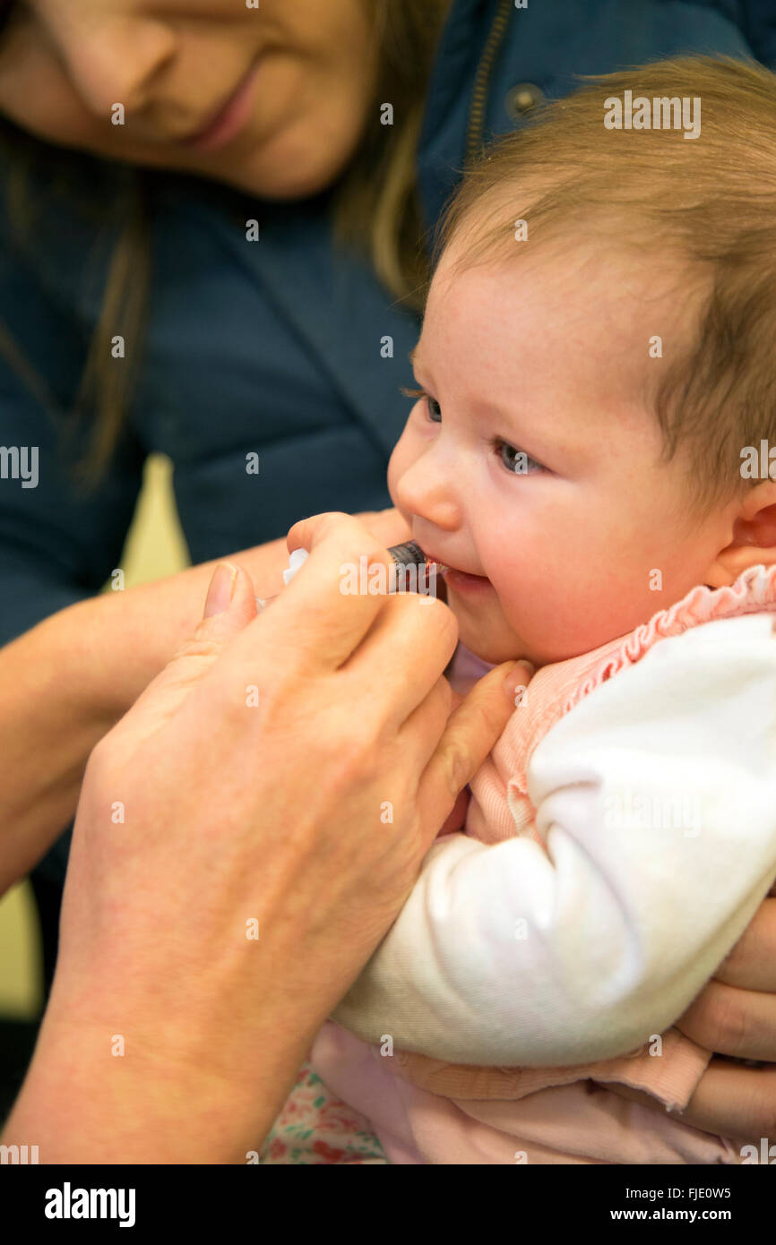 Baby having oral rotavirus vaccine immunisation Stock Photo