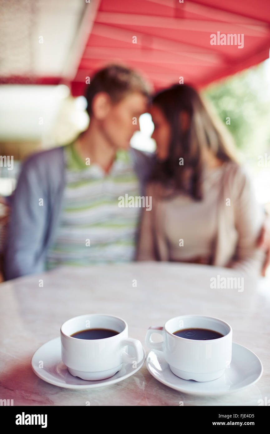 Two cups of coffee with couple in the background Stock Photo - Alamy