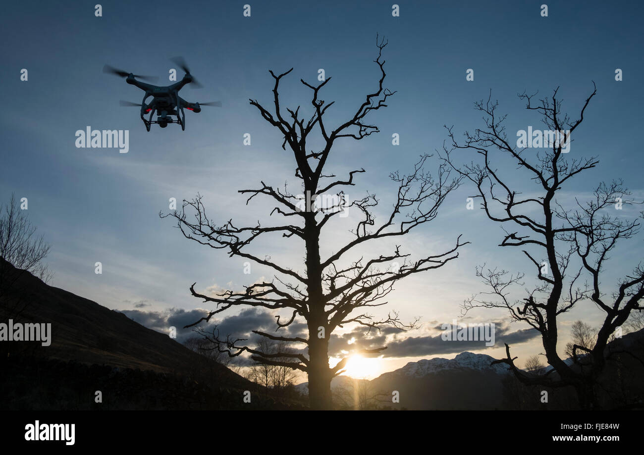 A radio controlled Drone Quadcopter flying at dusk. Stock Photo