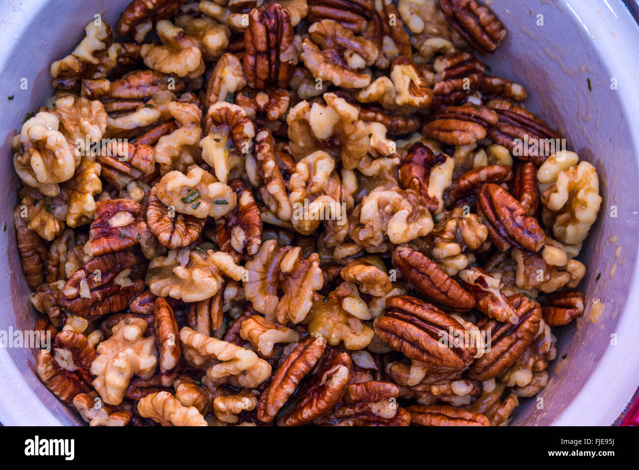 Preparing pecan nuts and walnuts in butter, water, garlic, rosemary