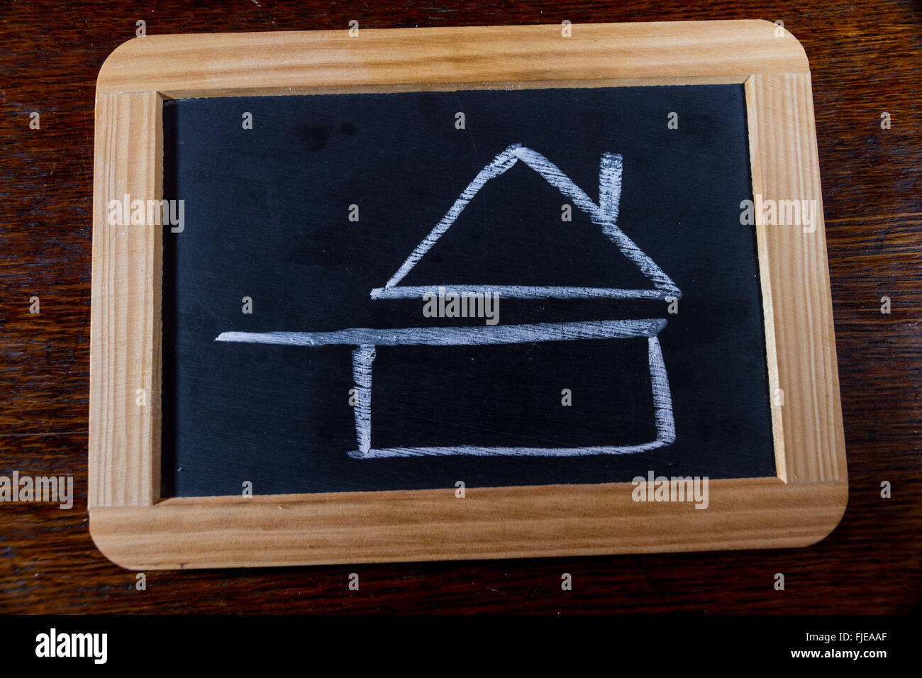 Blackboard with chalk symbol of home cooked food as drawn by child. Pan with roof. Stock Photo