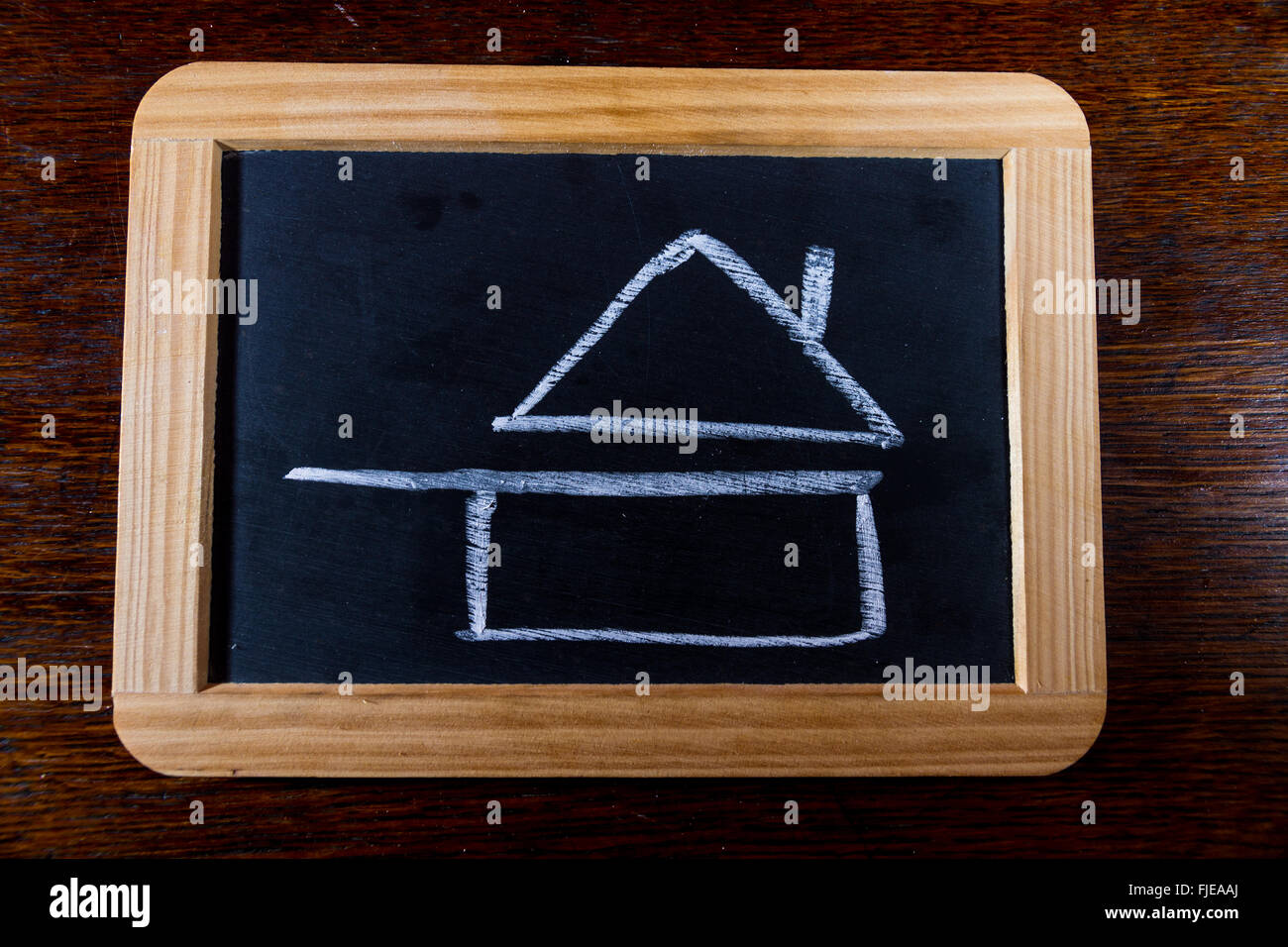 Blackboard with chalk symbol of home cooked food as drawn by child. Pan with roof. Stock Photo