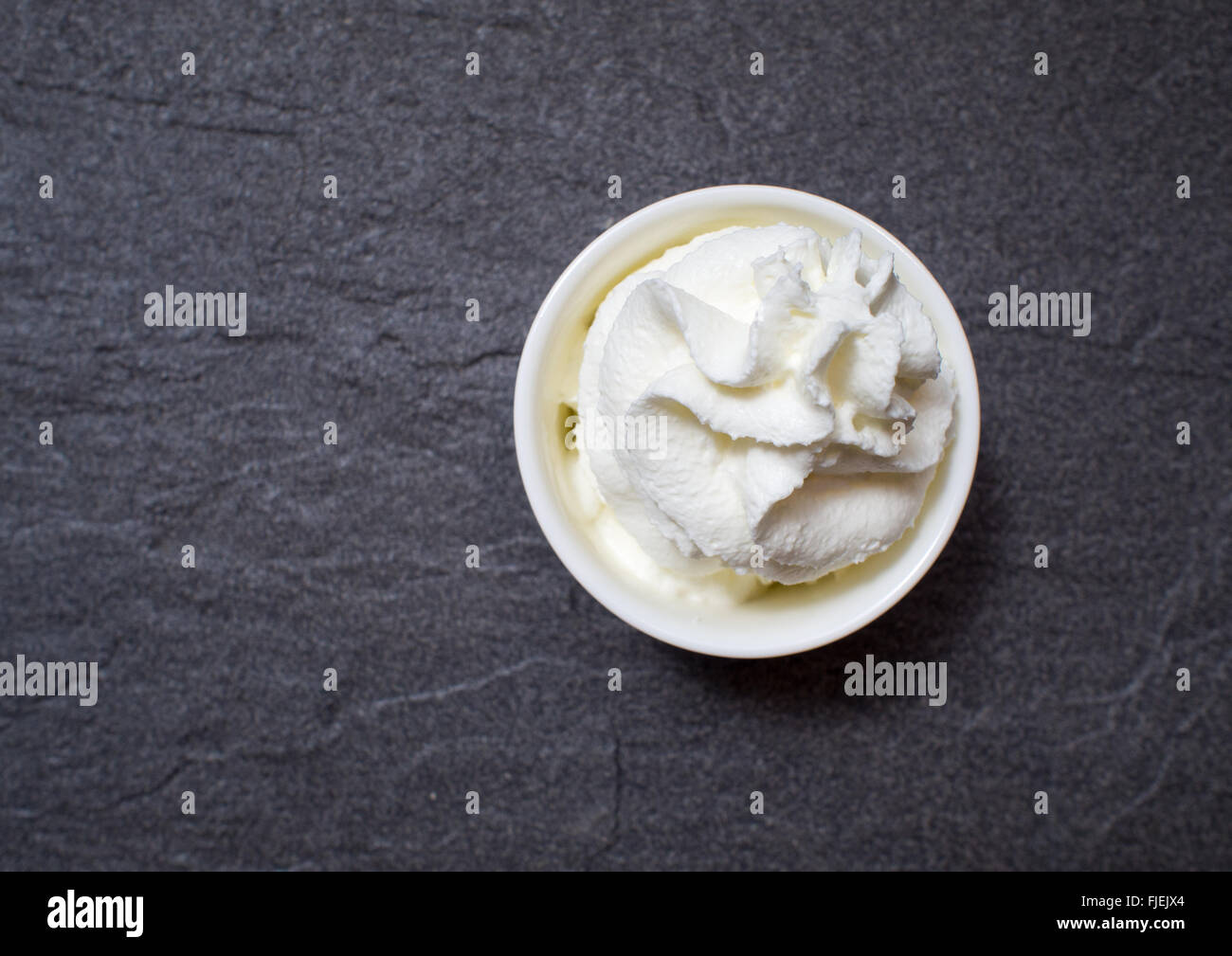 white whipping creme on black slate tone tile Stock Photo Alamy