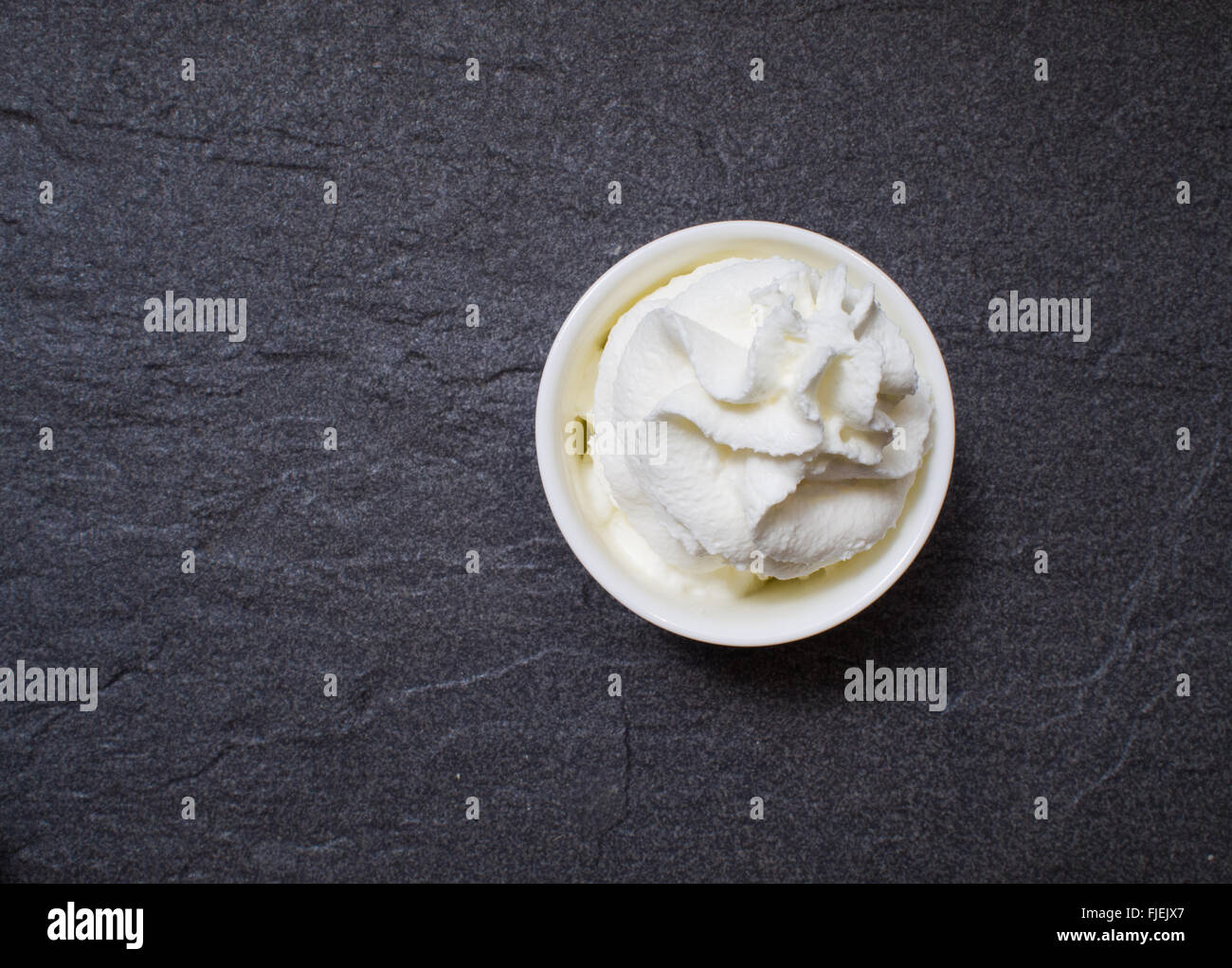 white whipping creme on black slate tone tile Stock Photo Alamy