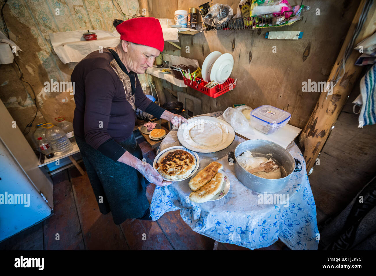 Old woman preparing traditional khachapuri and Lobiani in small bar next to road to Ushguli villages, Upper Svanetia, Georgia Stock Photo