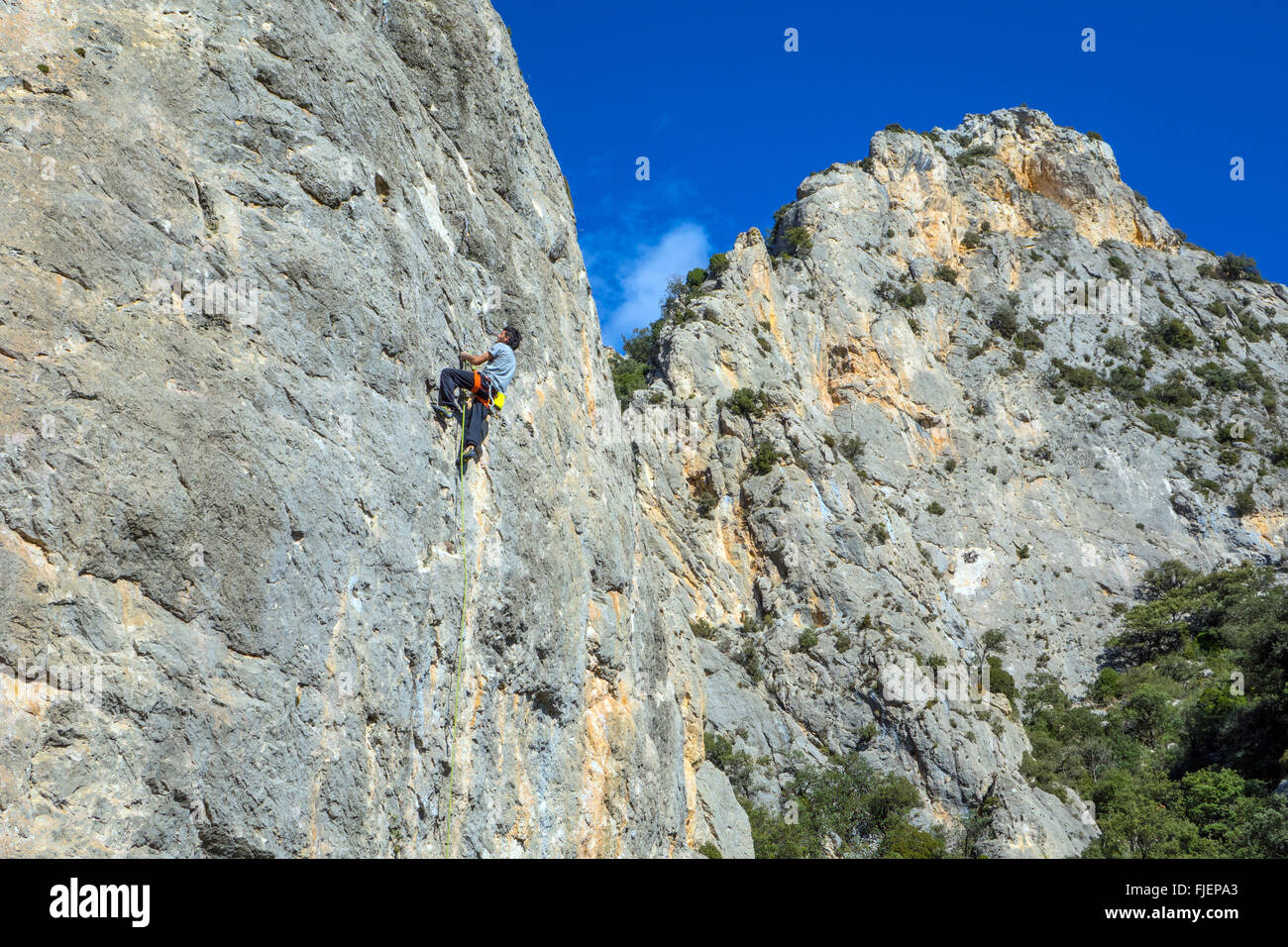 Male rock climber on steep limestone cliff Spain Stock Photo