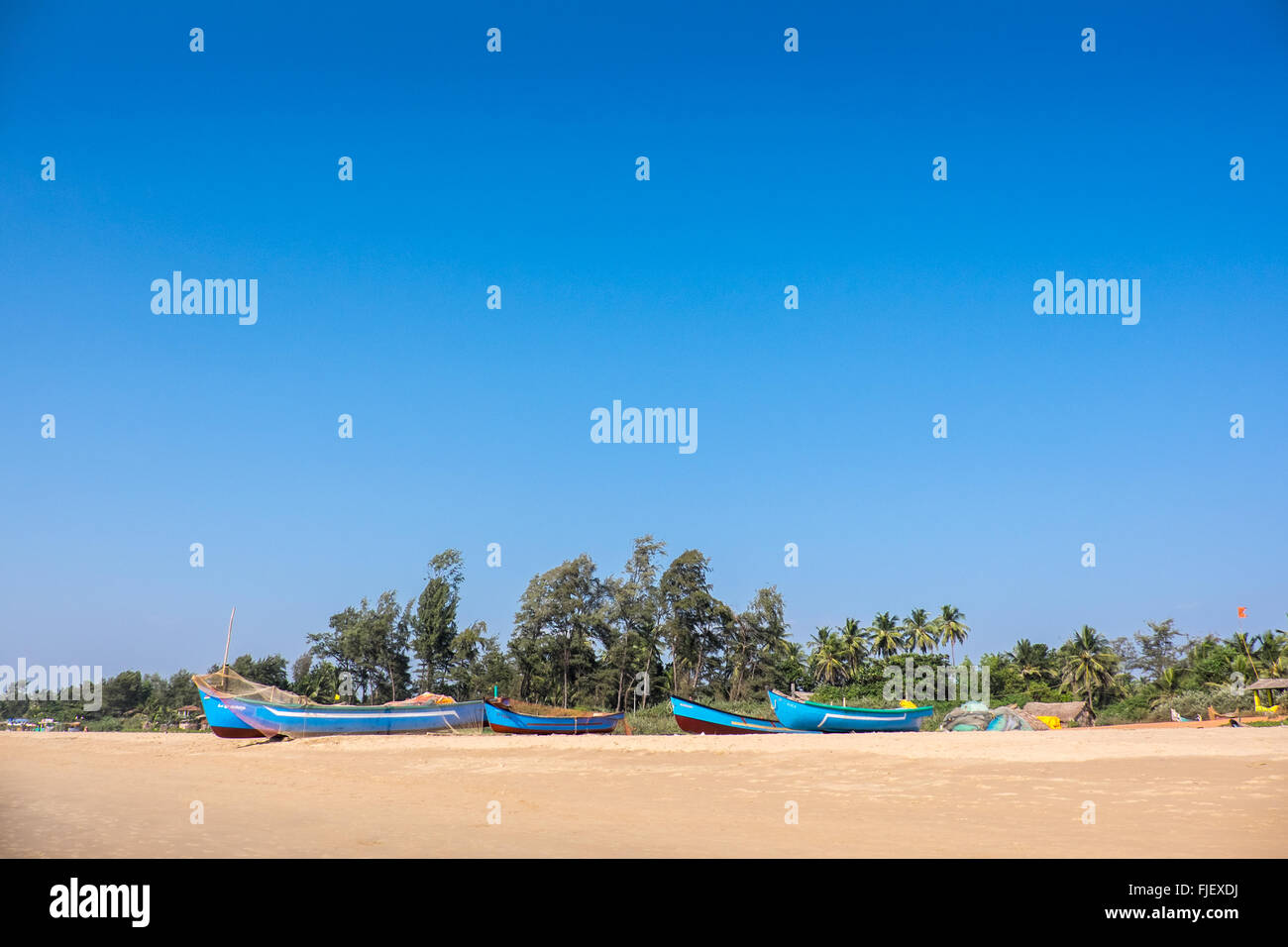 Brightly painted fishing boats on a beach in Kerala, India Stock Photo