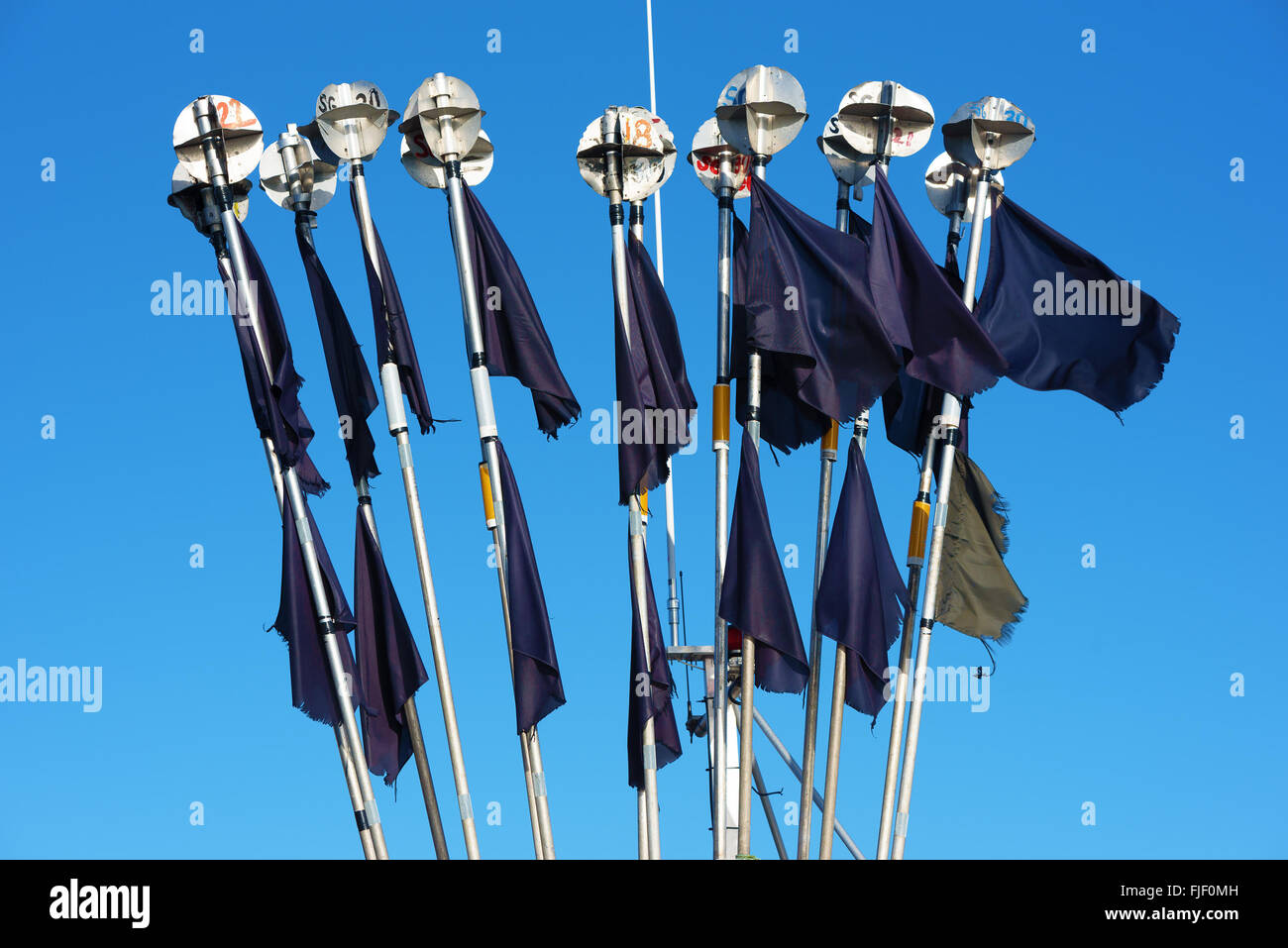 Nogersund, Sweden - February 27, 2016: A bunch of fisherman identity markers with black flags and metal radar reflectors on top. Stock Photo