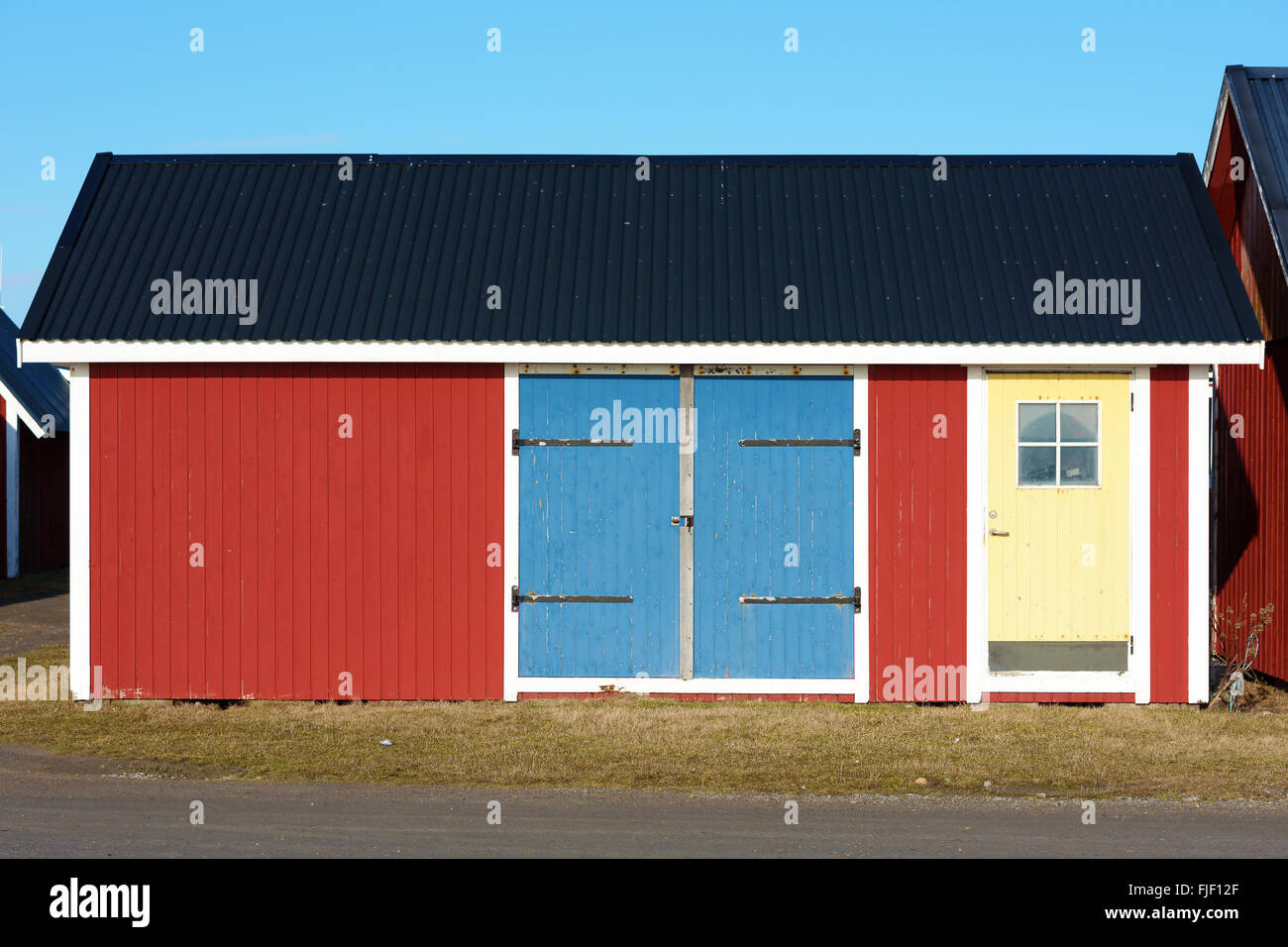 A Small Red Wooden Fishing Or Tool Shed With Blue And Yellow