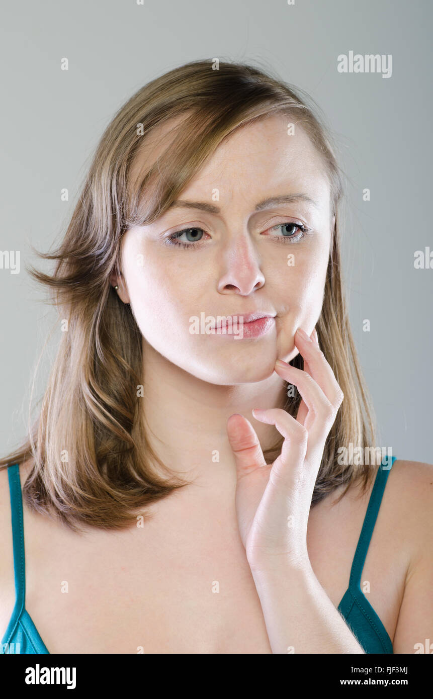 Annoyed woman hand on face looking away Stock Photo