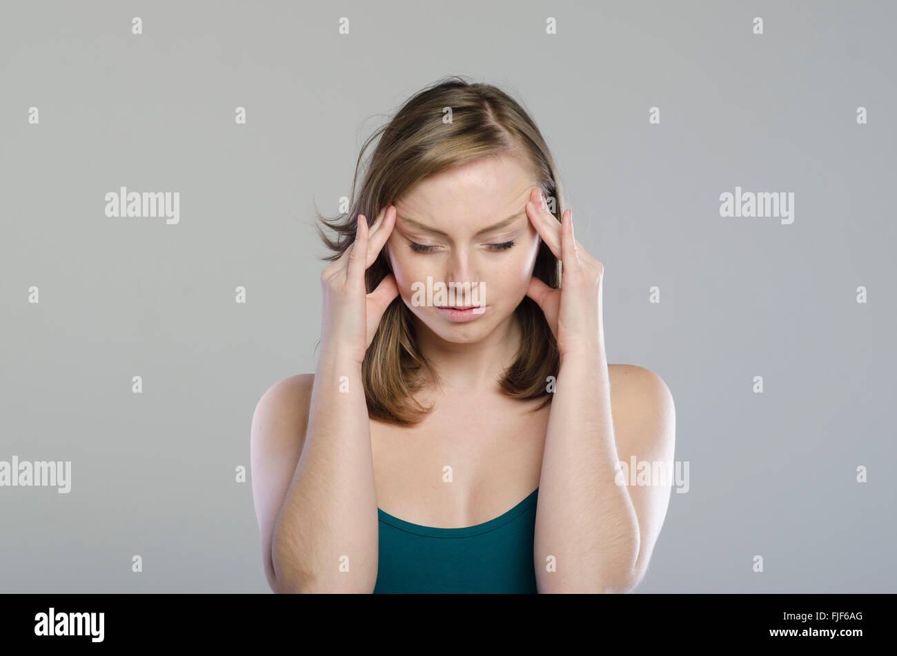 Young woman massaging her temples Stock Photo