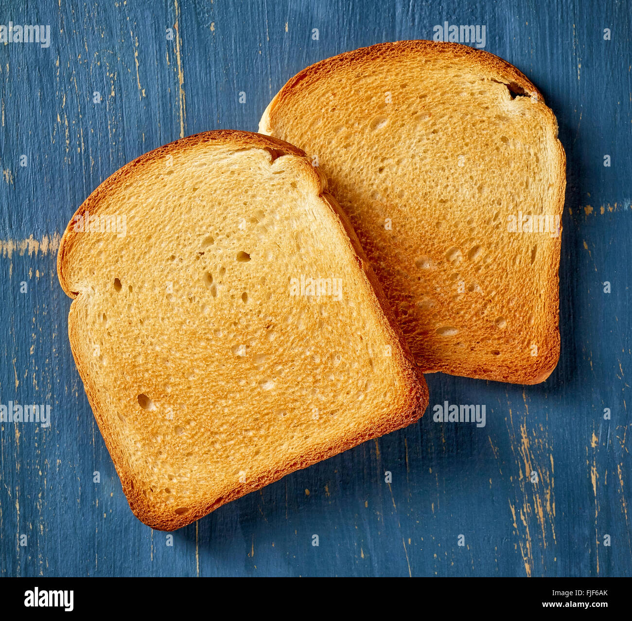 Pieces of sliced toast bread on blue wooden table, top view Stock Photo