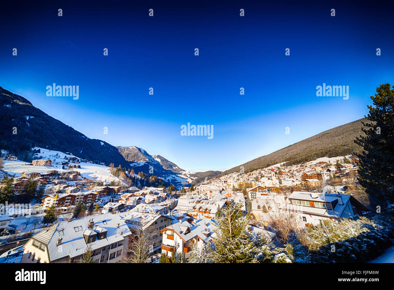Dawn on snowy rooftops of a village nestled in the mountains Stock Photo