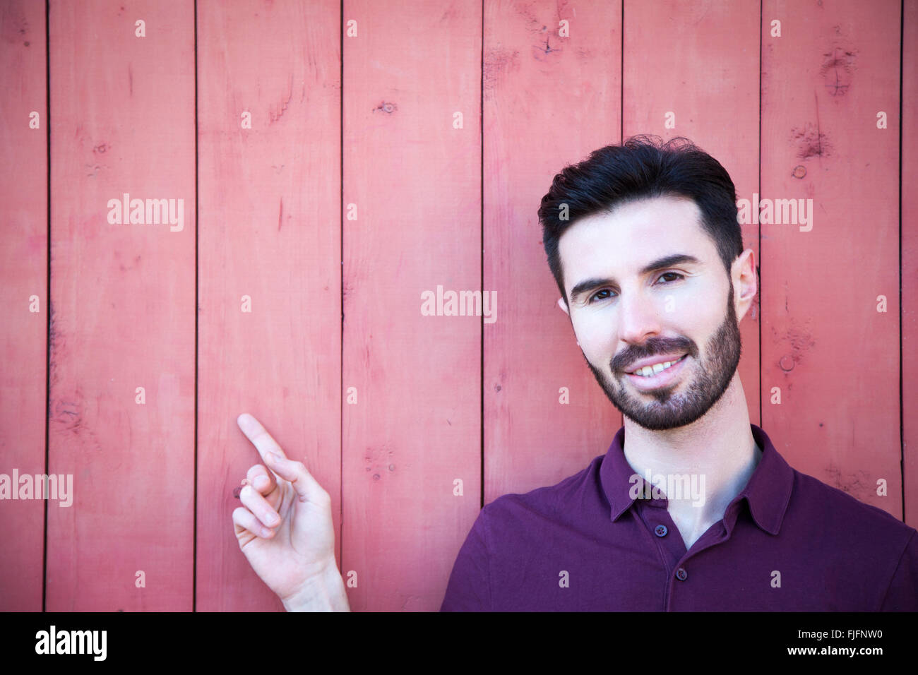 Portrait of an attractive young man pointing to the side Stock Photo