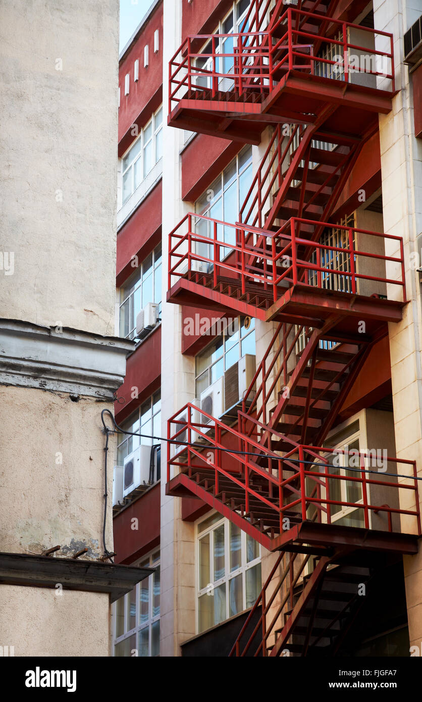 Red emergency staircase in a building facade. Vertical Stock Photo Alamy