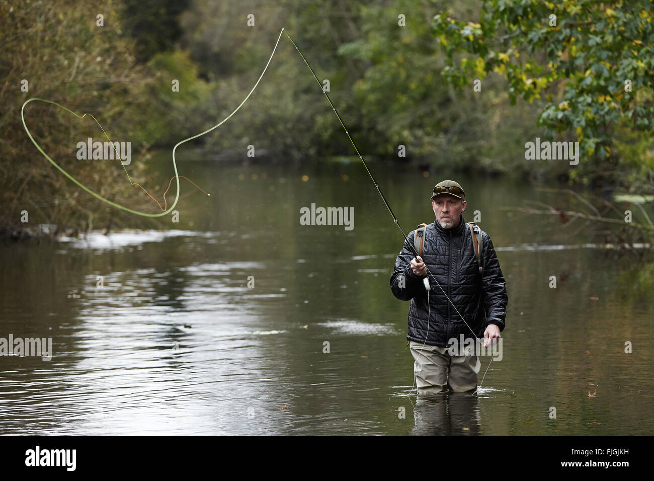 A man fly fishing in a river - London, UK Stock Photo