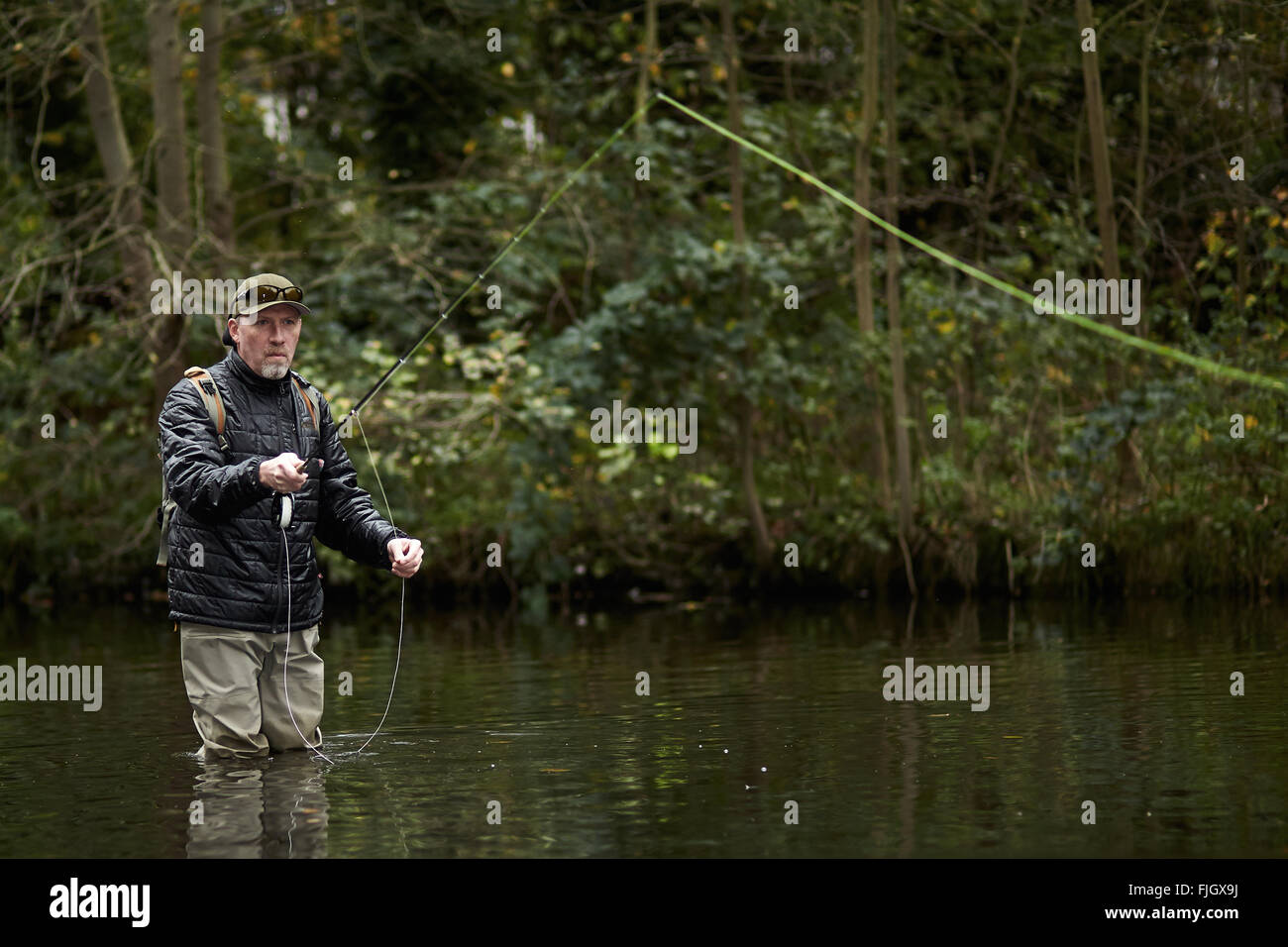 A man fly fishing in a river - London, UK Stock Photo