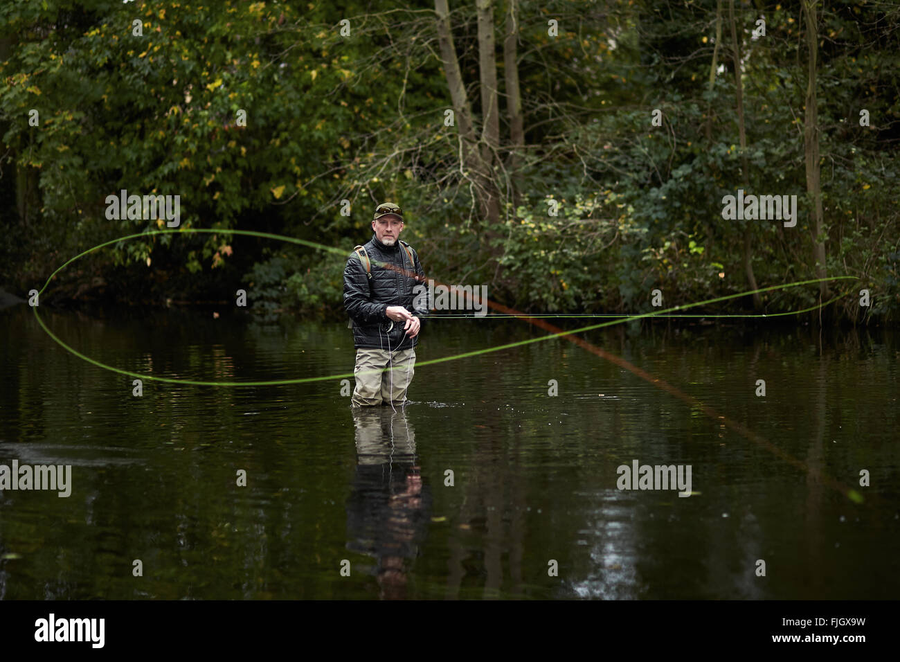 A man fly fishing in a river - London, UK Stock Photo
