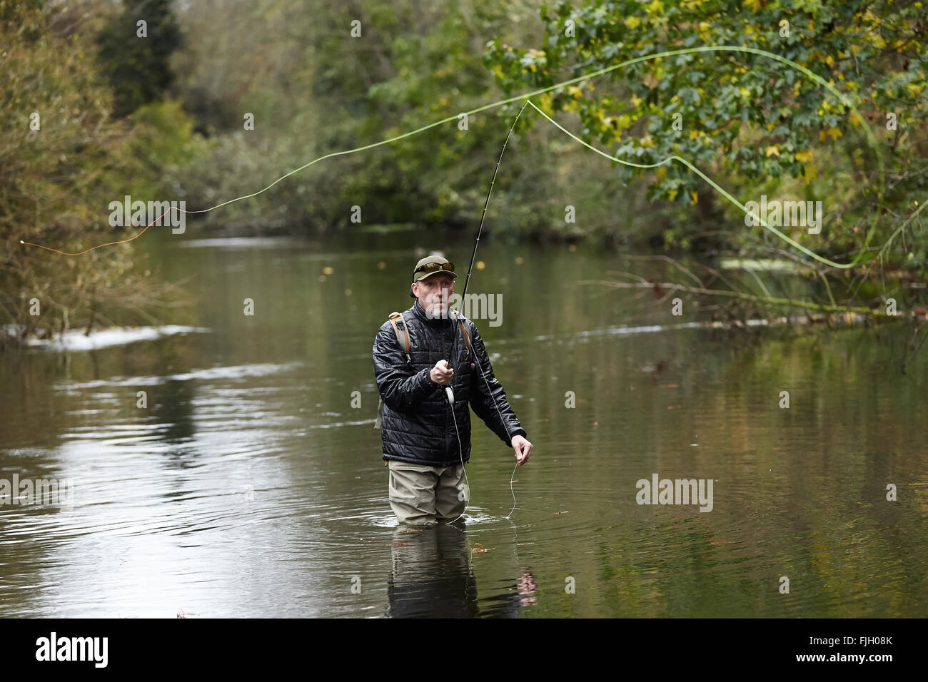 A man fly fishing in a river - London, UK Stock Photo