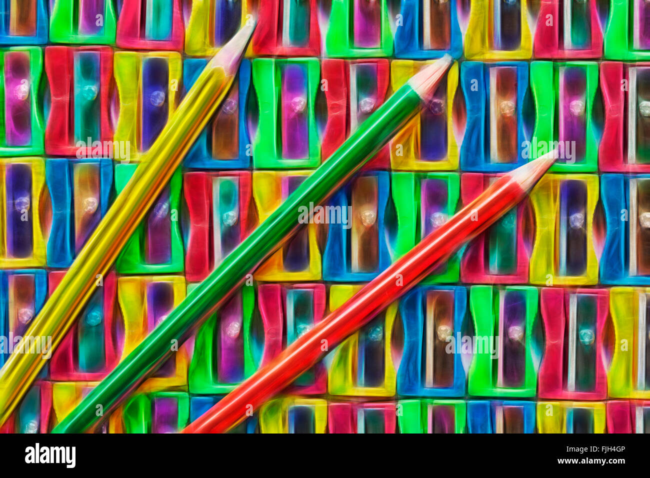 Rows of colourful red, yellow, green and blue plastic pencil sharpeners with pencils that need