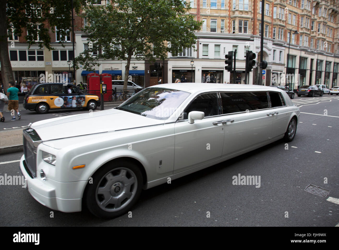 Stretch limousine Rolls Royce in Knightsbridge, London, UK. IN this wealthy part of West London, examples of extreme wealth and exclusive lifestyle are oppulantly on show everywhere you look. The choice of what car you drive or what clothes you wear all gives off an appearance of your rich status. Stock Photo