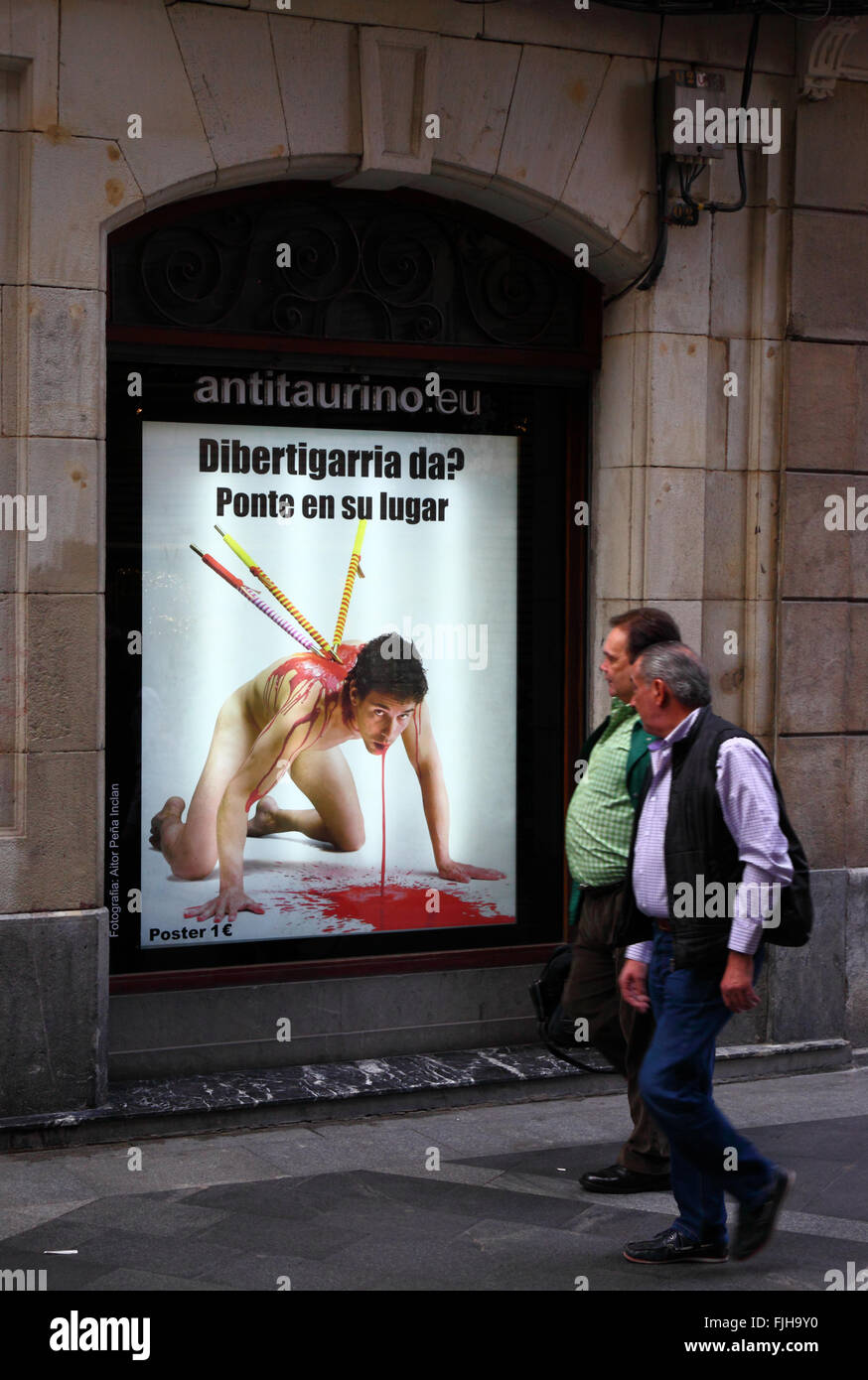 People walking past a poster in window protesting against bullfighting, Casco Viejo, Bilbao, Basque Country, Spain Stock Photo
