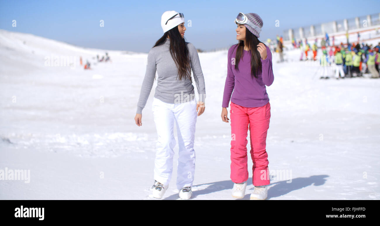 Two attractive young woman walking in fresh snow Stock Photo - Alamy