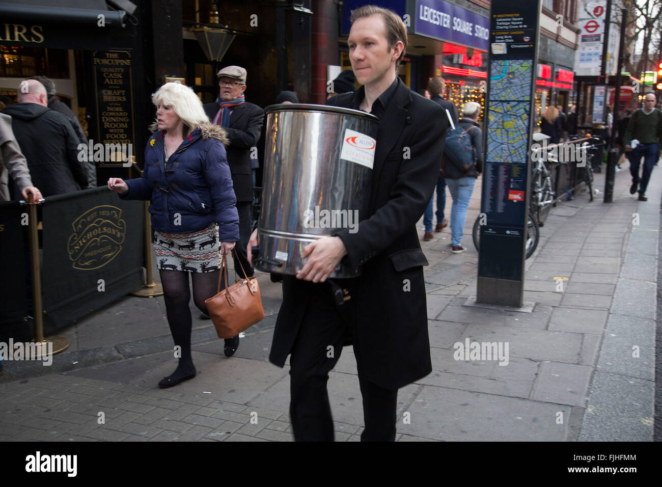 https://c8.alamy.com/comp/FJHFMM/man-carrying-a-tea-urn-along-charing-cross-road-london-uk-an-unusual-FJHFMM.jpg
