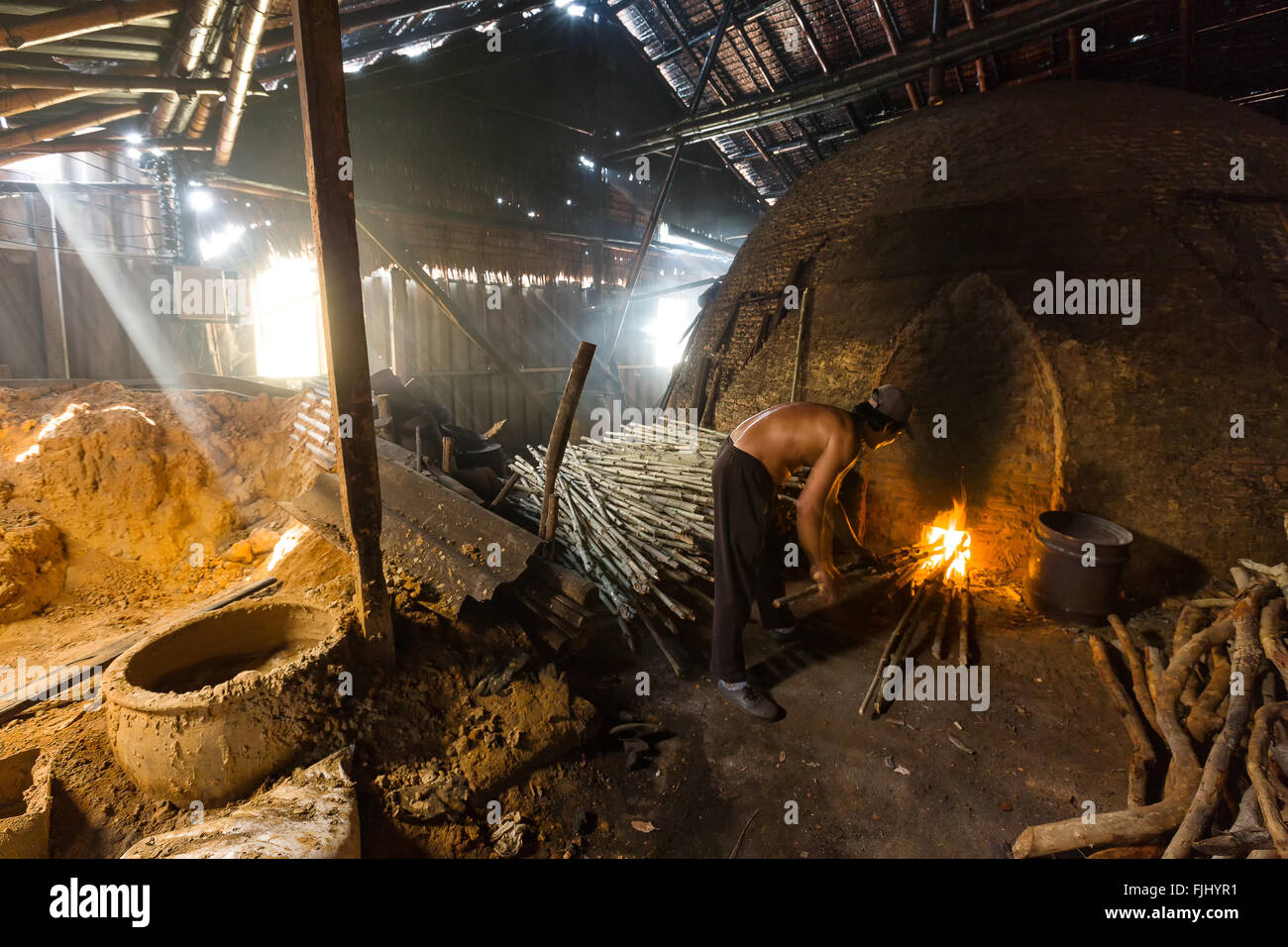 A charcoal worker at work on a pile of slow burning wood charcoal factory Stock Photo Alamy