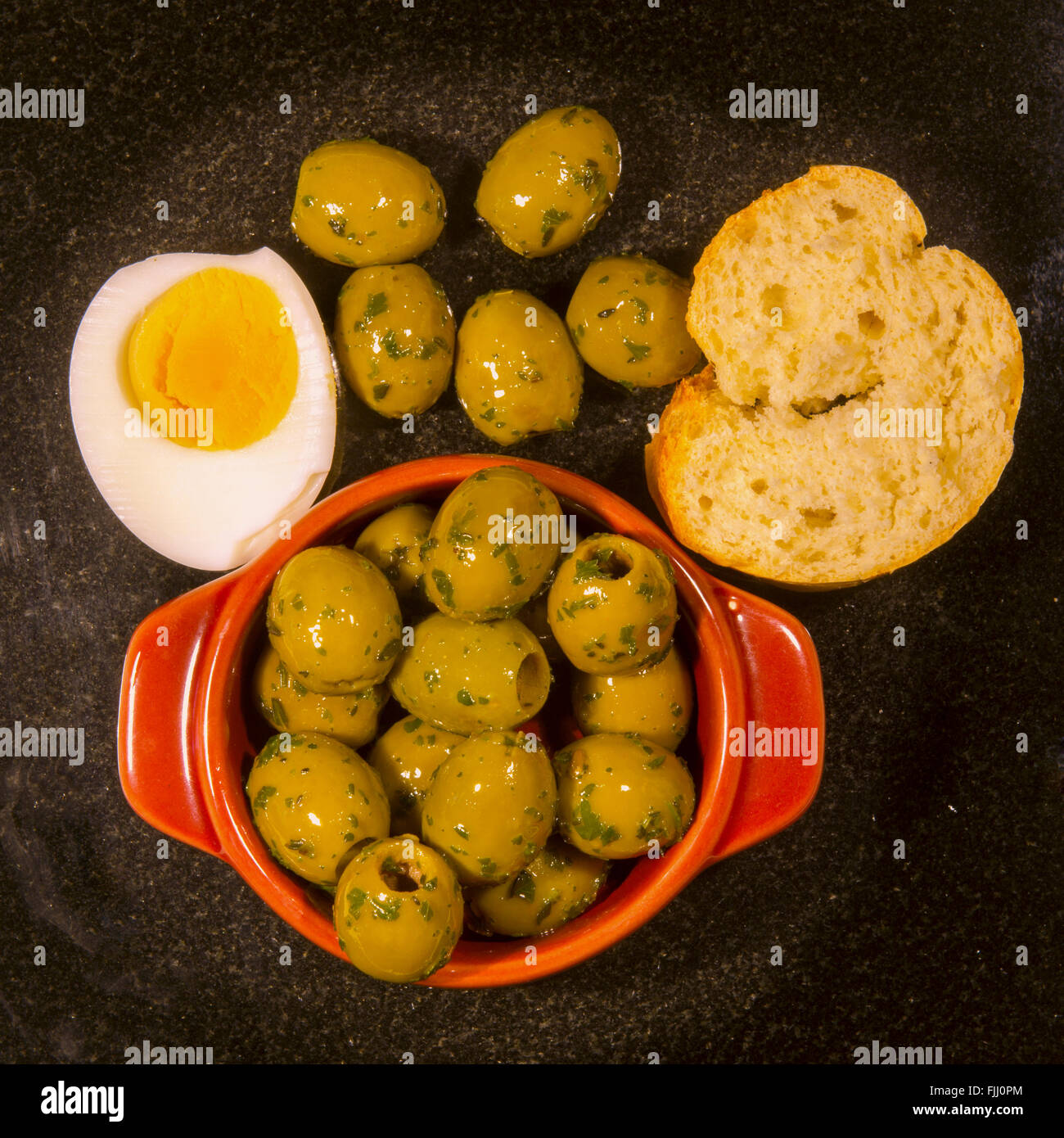 Platter of olives, hard boiled egg and French bread Stock Photo Alamy