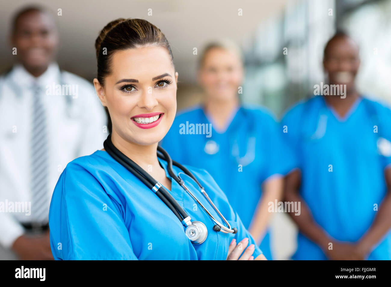 attractive young medical doctor and colleagues in hospital Stock Photo