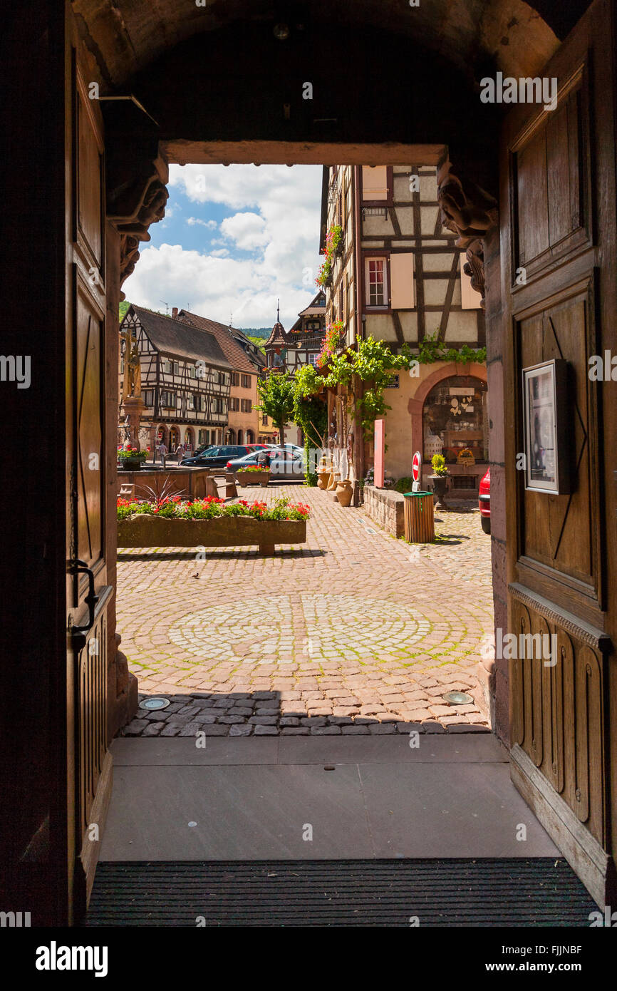 View of the Old Market square  through the door of Sainte Croix church Kaysersberg , Alsace, Haut-Rhin, France Stock Photo