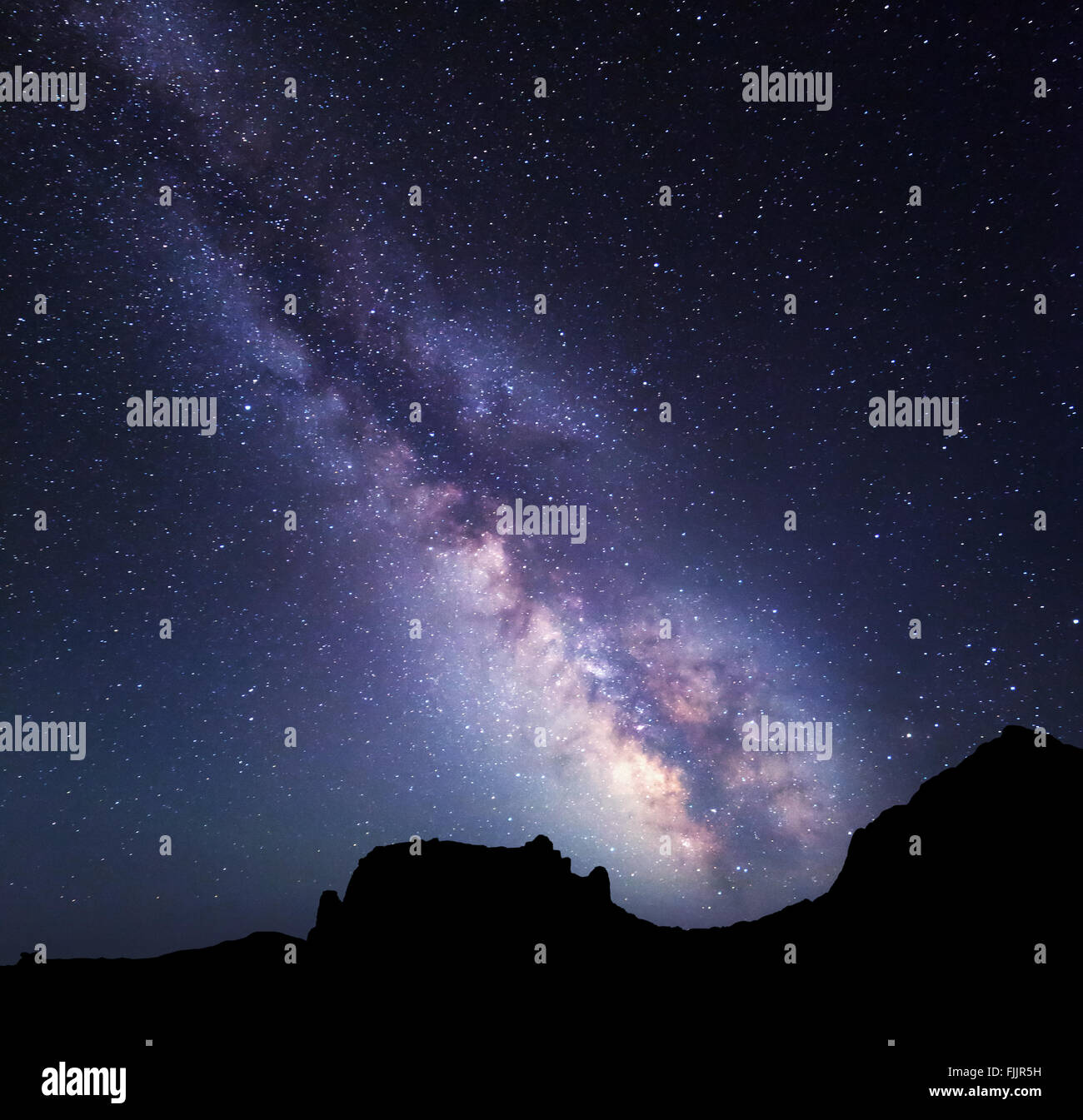 Night landscape with colorful Milky Way at mountains. Starry sky with rocks at summer. Beautiful Universe Stock Photo