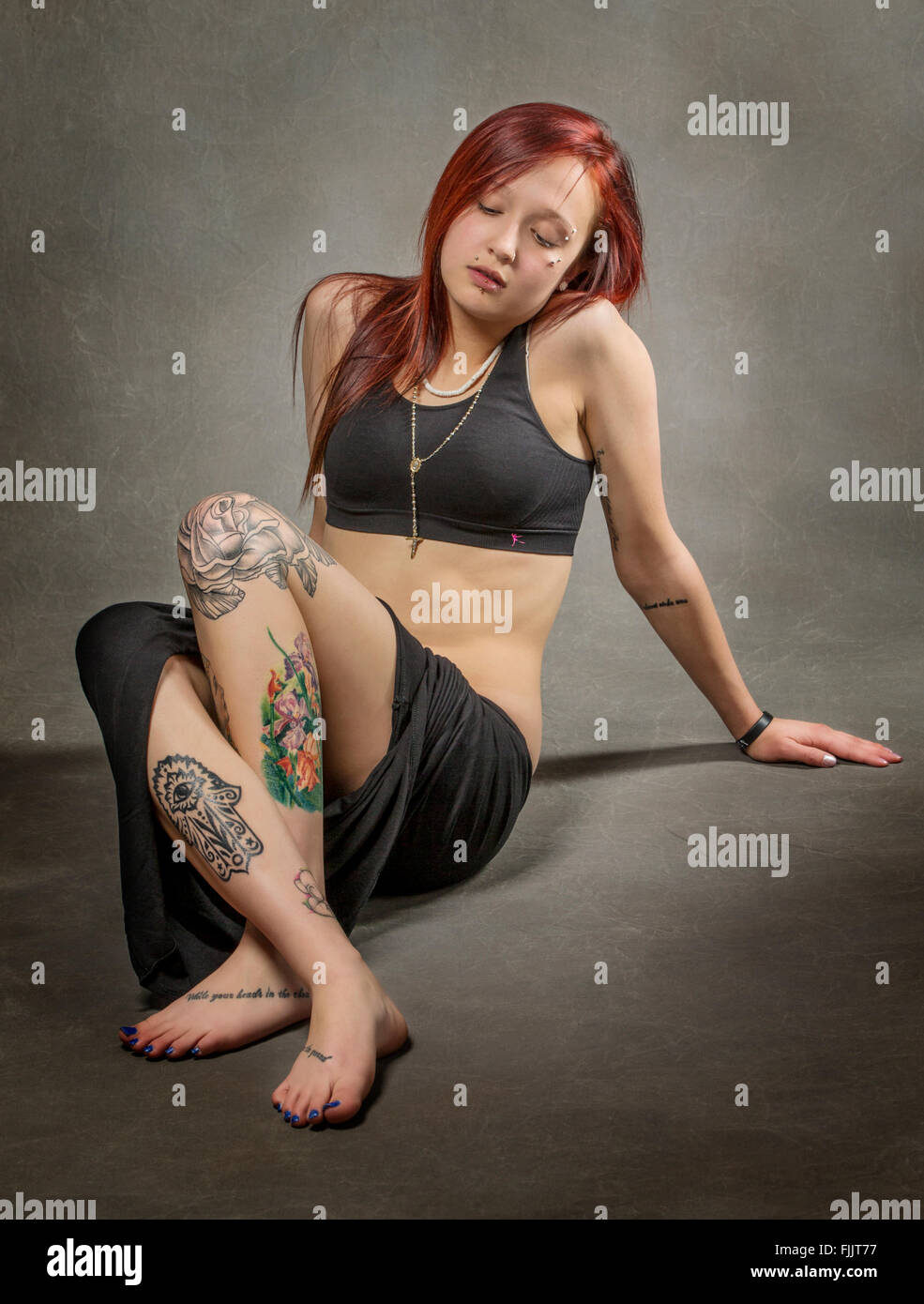 Studio portrait of tattoos and body piercings on an attractive, fit
