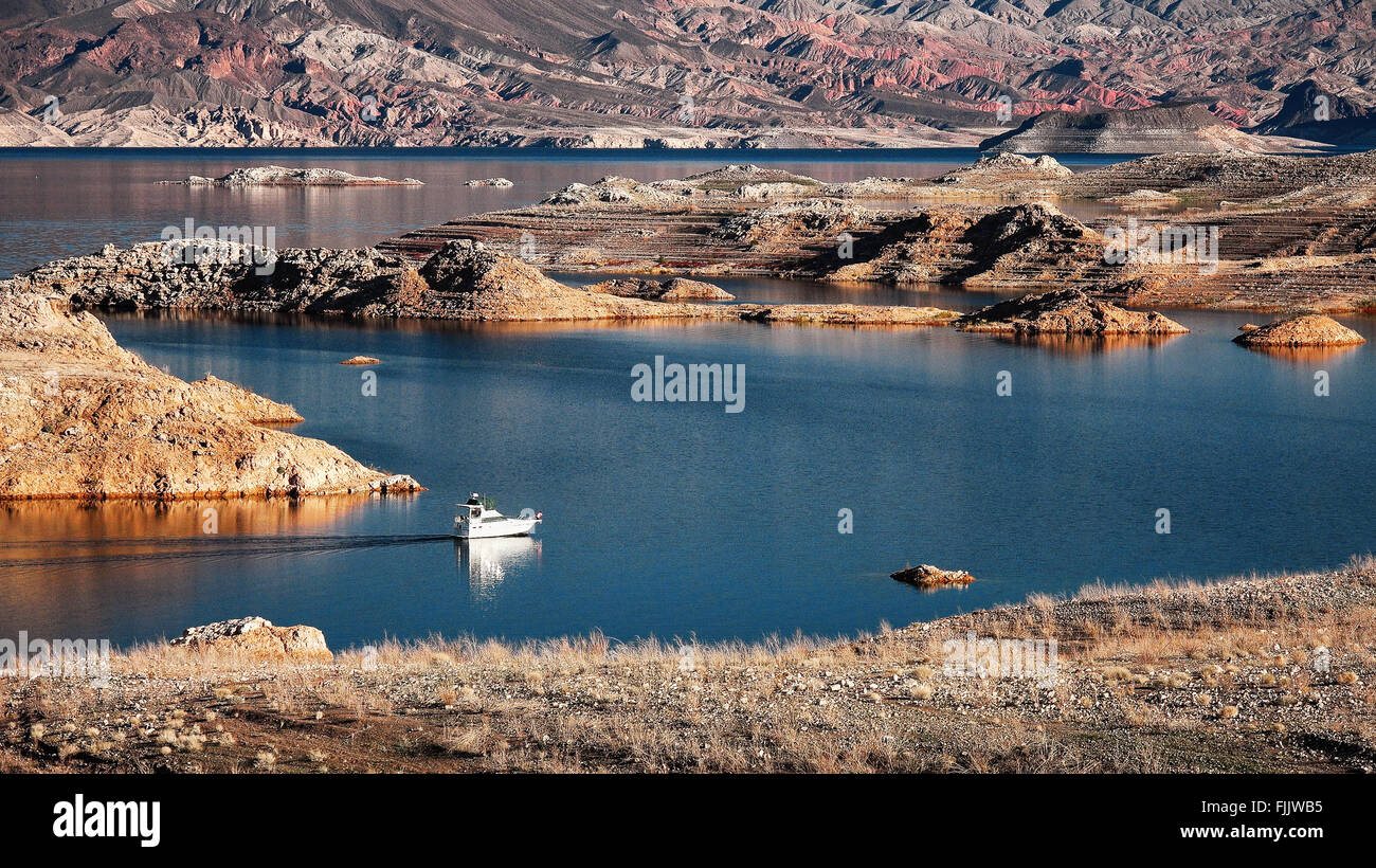 A white motorboat cruising through a channel in Lake Mead Stock Photo