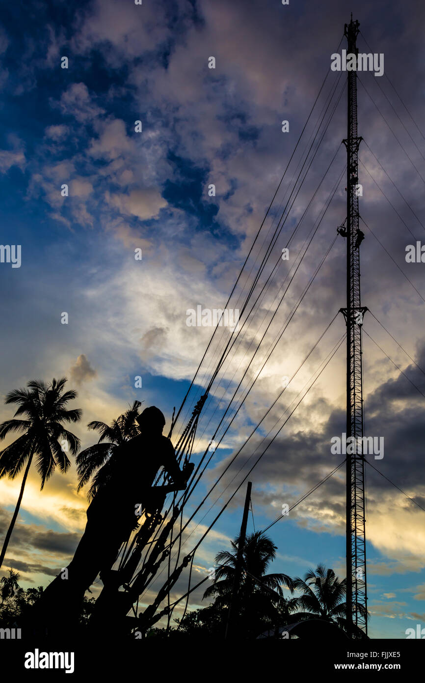 A Silhouette Photo of Phone tower antenna technician are doing to repair a slings cable. Stock Photo