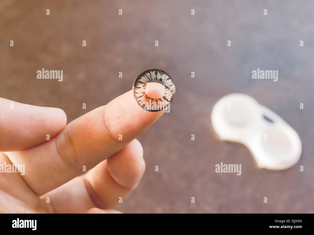 Hand taking black and grey contact lense with copy space Stock Photo