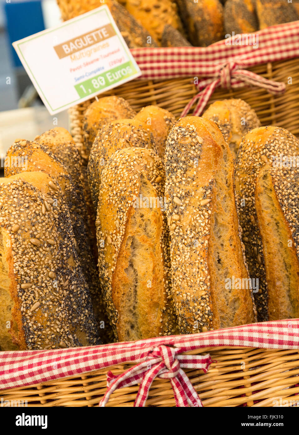 Typical French bread seeded baguettes displayed in wicker baskets at a local street market