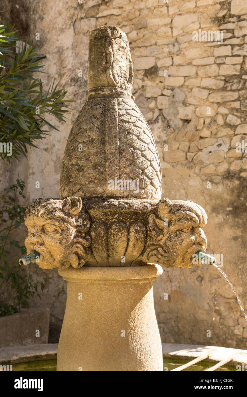 The Fontaine des Mascarons, an old stone fountain in the historic village of Seguret, Vaucluse, Provence, France Stock Photo