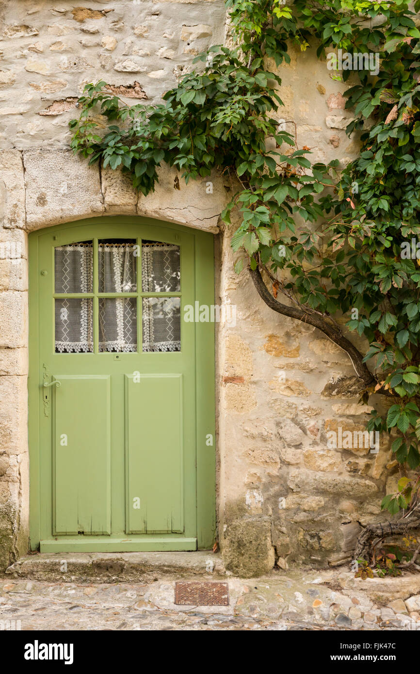 Detail of a painted wood door and stone wall in the Medieval village of Vaison la Romaine, Provence, France Stock Photo