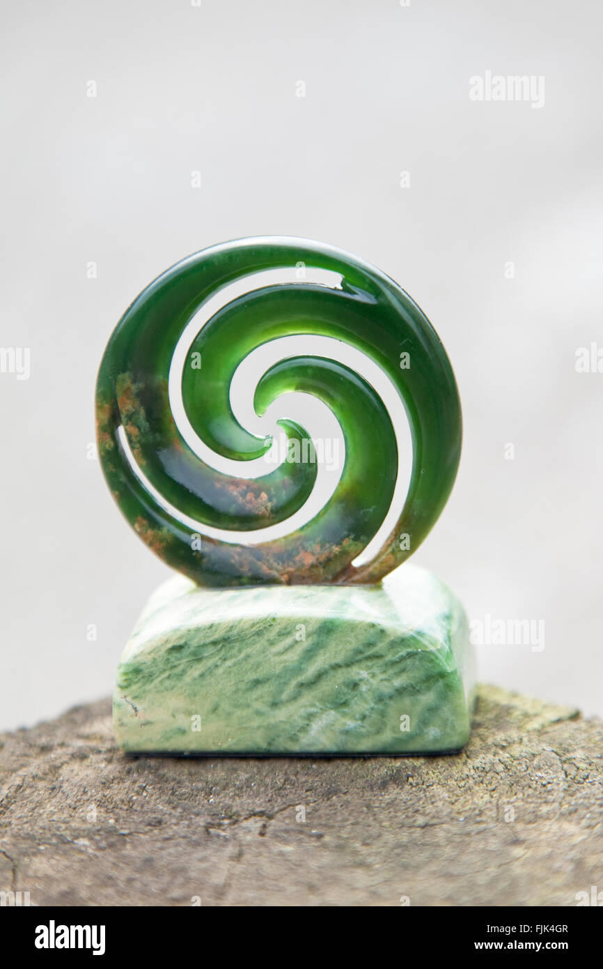 New Zealand jade, also called greenstone or pounamou, carved into traditional Maori 'koru' shape to represent a fiddlehead fern Stock Photo