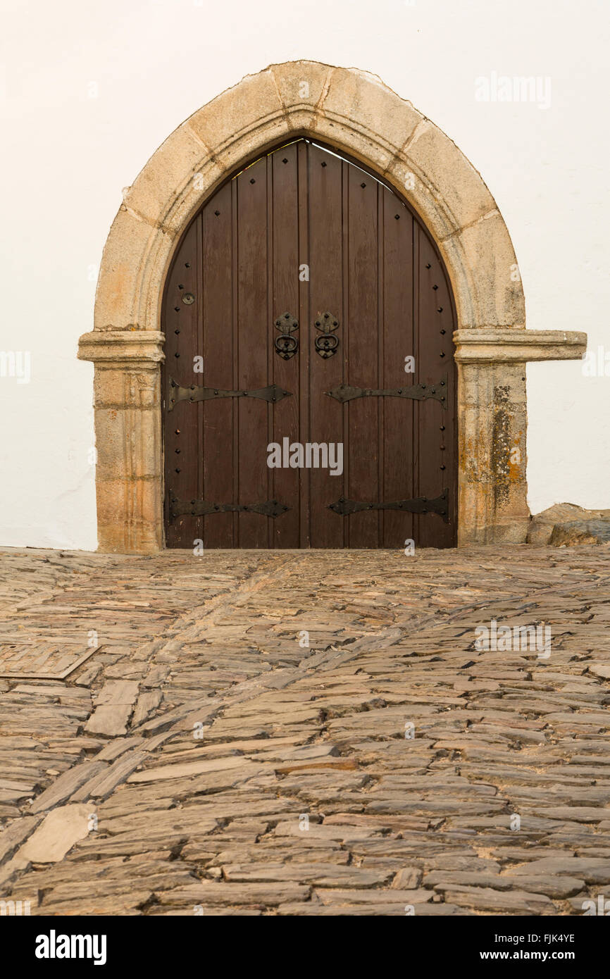 Arched doorway and cobblestone street in the historic village of Monsaraz, Alentejo region, Portugal. Medieval architecture travel sights. Stock Photo
