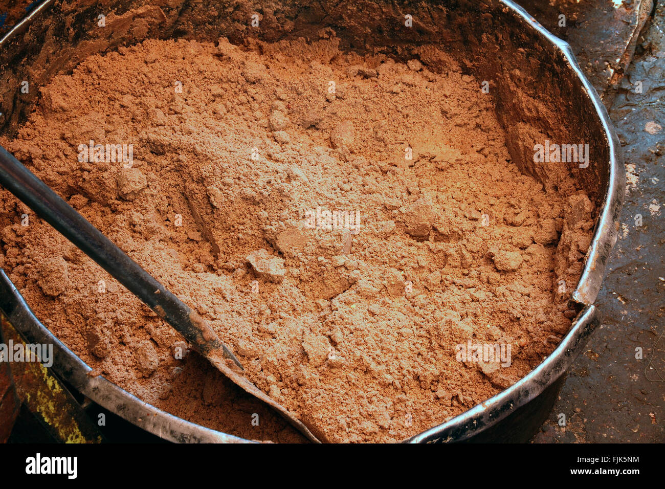 A large metal vat of ground peanuts before adding oil to make peanut butter. Stock Photo