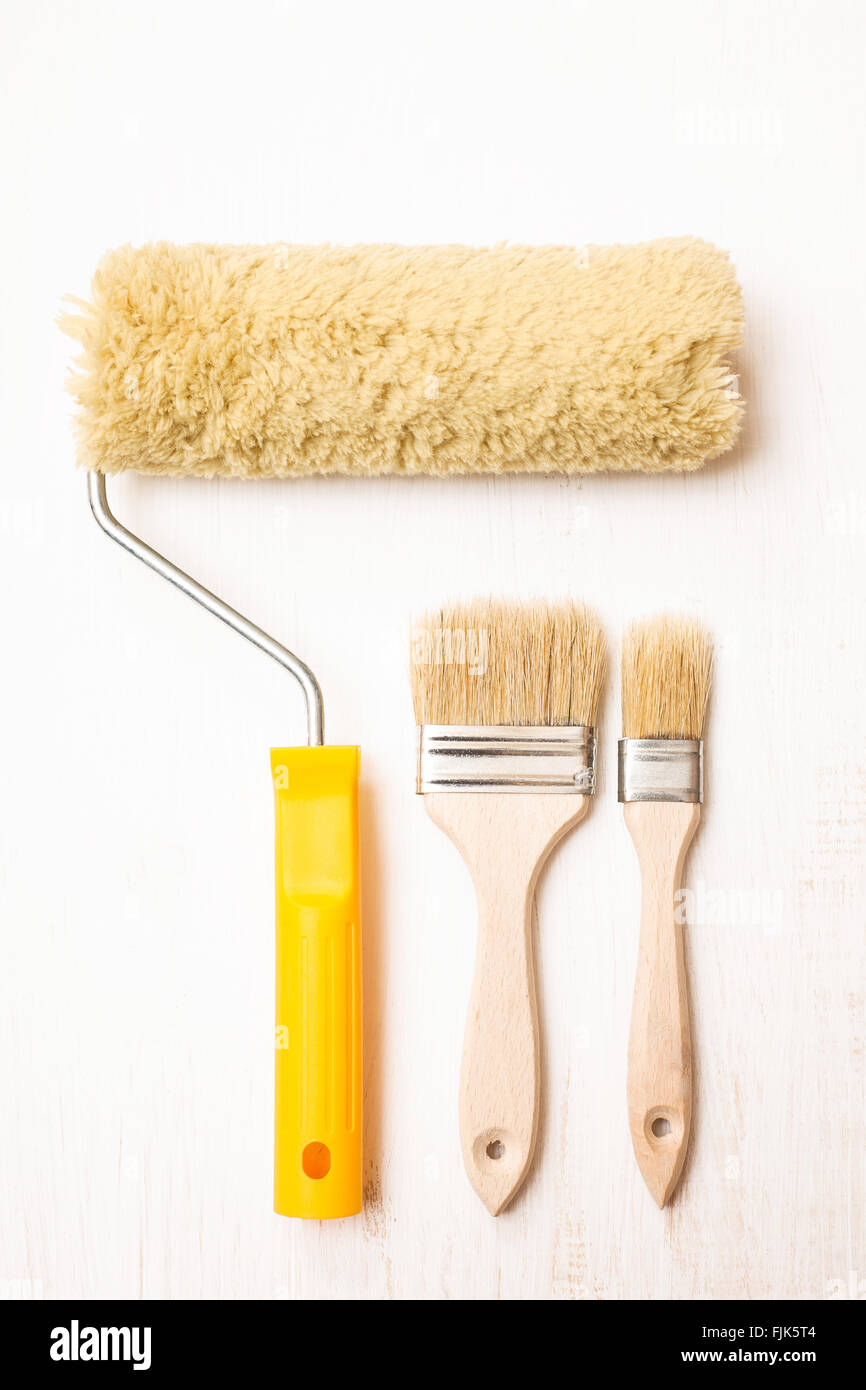 Two paint brushes and roller on white wooden background Stock Photo Alamy