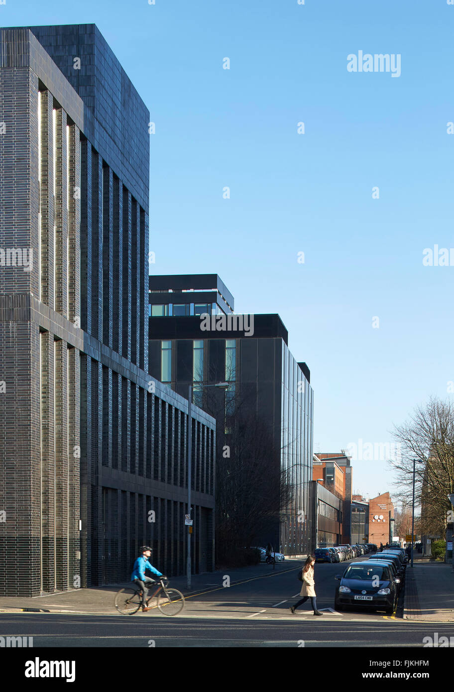 Street elevation with black brick facade. MMU Student Union, Manchester, United Kingdom. Architect: Feilden Clegg Bradley Studio Stock Photo