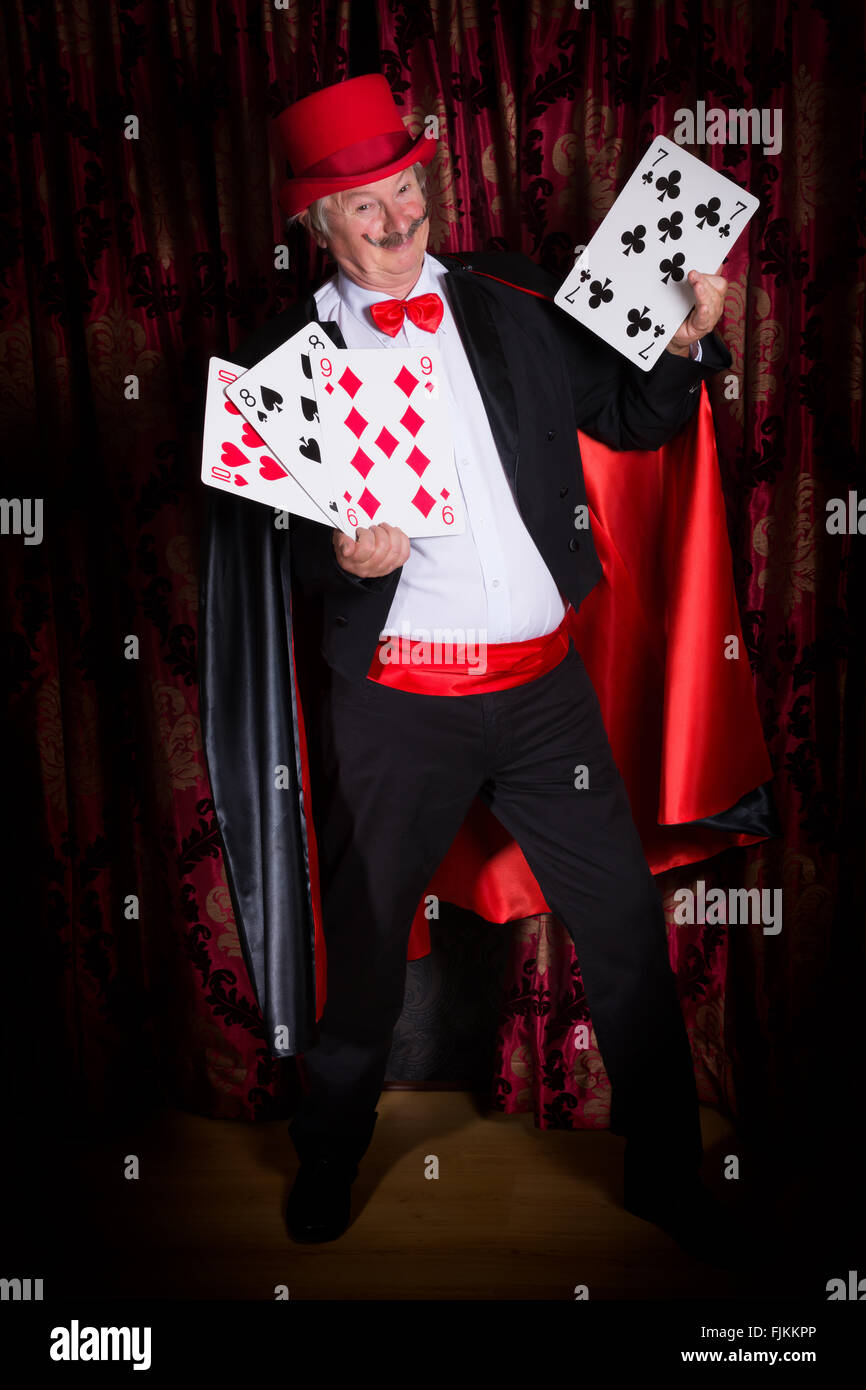 https://c8.alamy.com/comp/FJKKPP/mature-magician-on-stage-performing-a-magic-trick-with-cards-FJKKPP.jpg