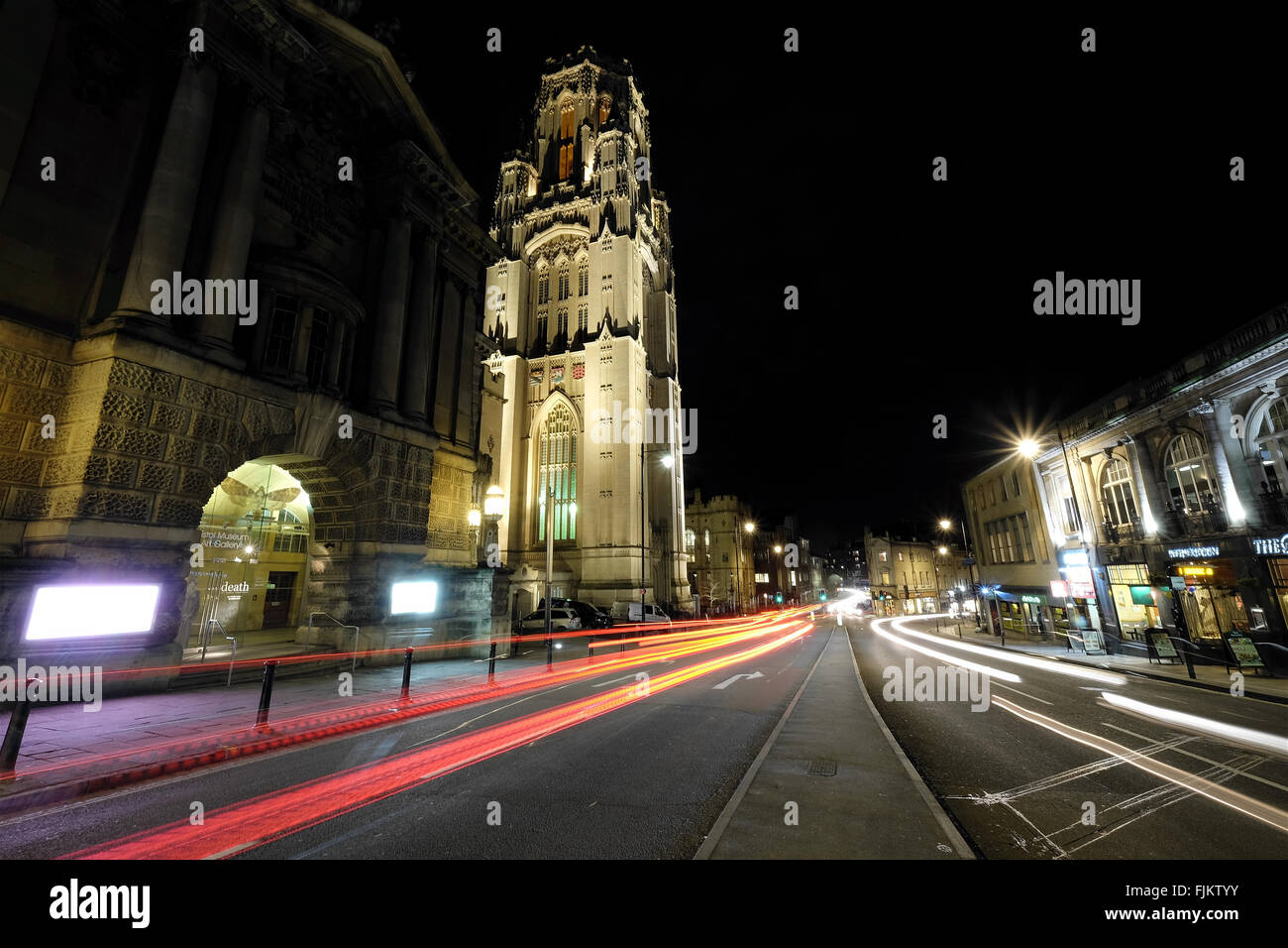 A night photograph of Bristol's Wills Tower and Bristol Museum, showing light trails from passing traffic Stock Photo