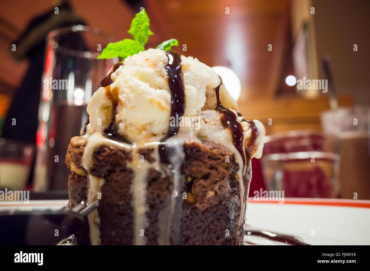 Molten chocolate cake with ice cream and mint leaf. Some other names used are chocolate fondant, chocolate moelleux Stock Photo