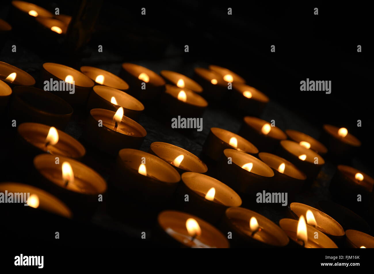 Votive candles against a black background Stock Photo