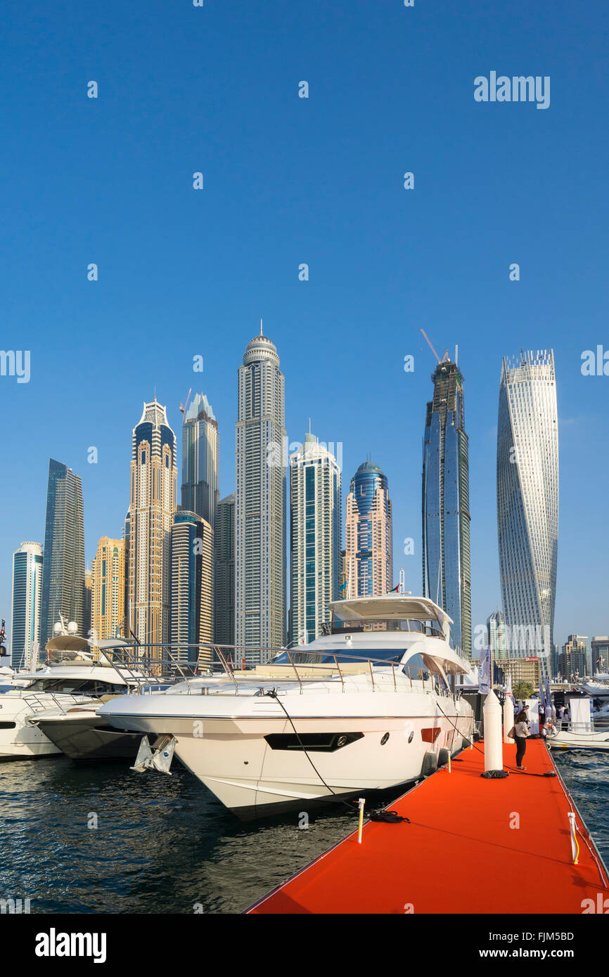 Luxury motor yachts on display with skyline of skyscrapers at the Dubai International Boat Show 2016 Stock Photo